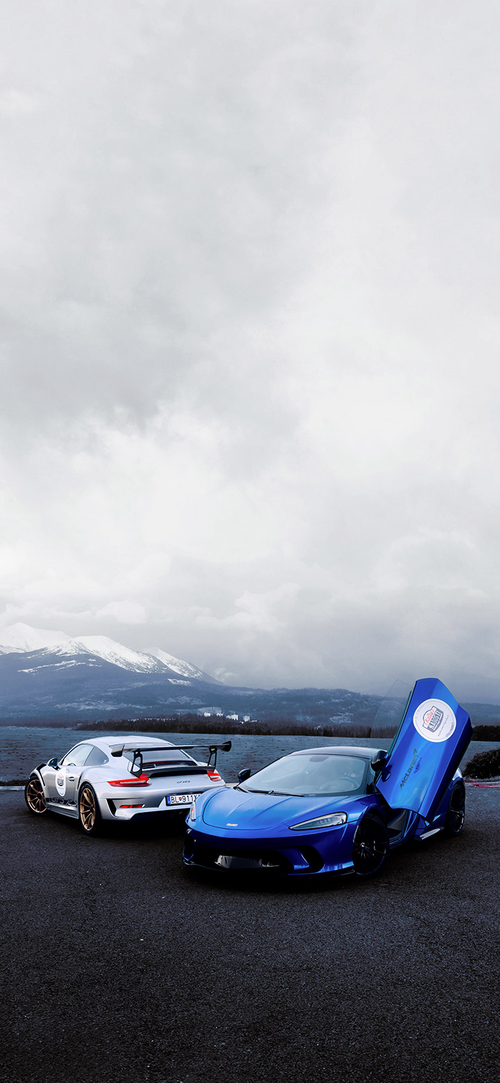 wallpaper of two sports cars parked near a mountain