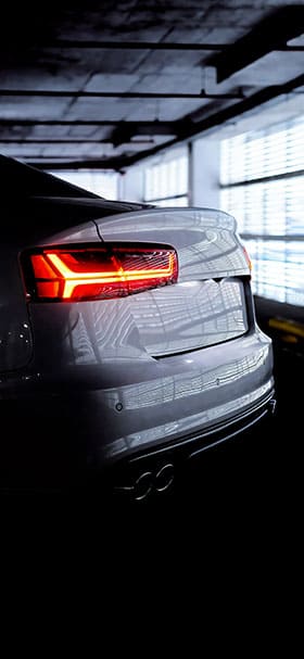Phone wallpaper of The back of an Audi car in a dark garage