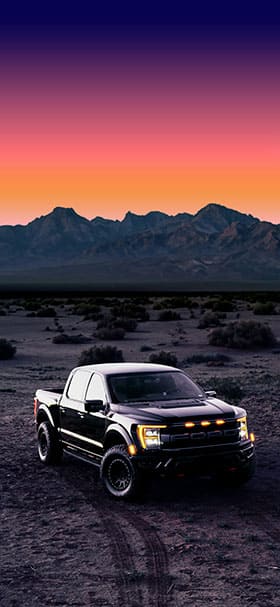 Phone wallpaper of Black Ford truck in the dark desert