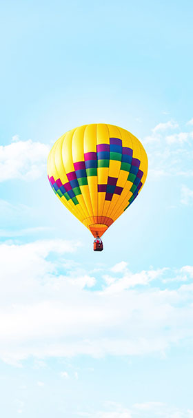 phone wallpaper of yellow hot air balloon in midair