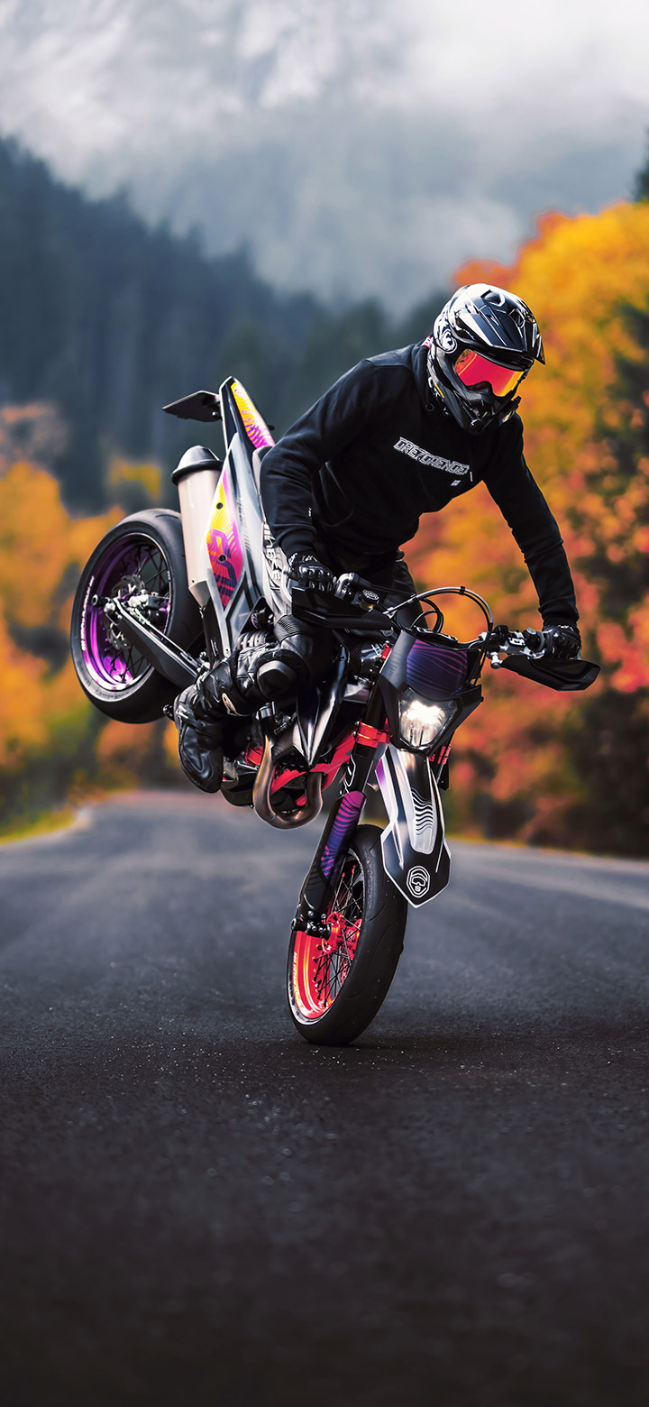 wallpaper of Man Performing Stoppie Stunt On A Motorcycle